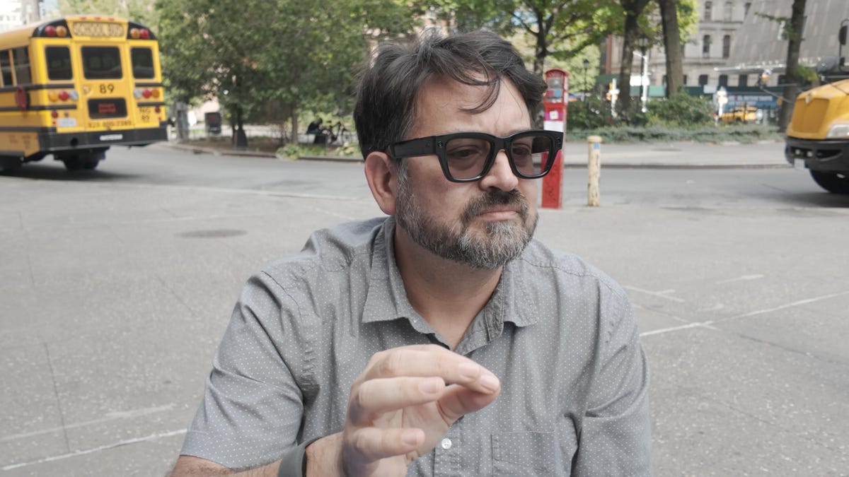 CNET's Scott Stein wearing a neural band and wearing Meta Ray-Ban Display sunglasses outside
