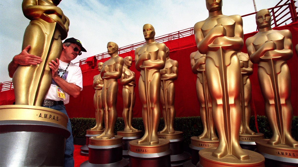 005306.ME.0327.oscar1.rm Mark Ross?Sullivan carries a fiberglass Oscar statue. Several hundred peopl