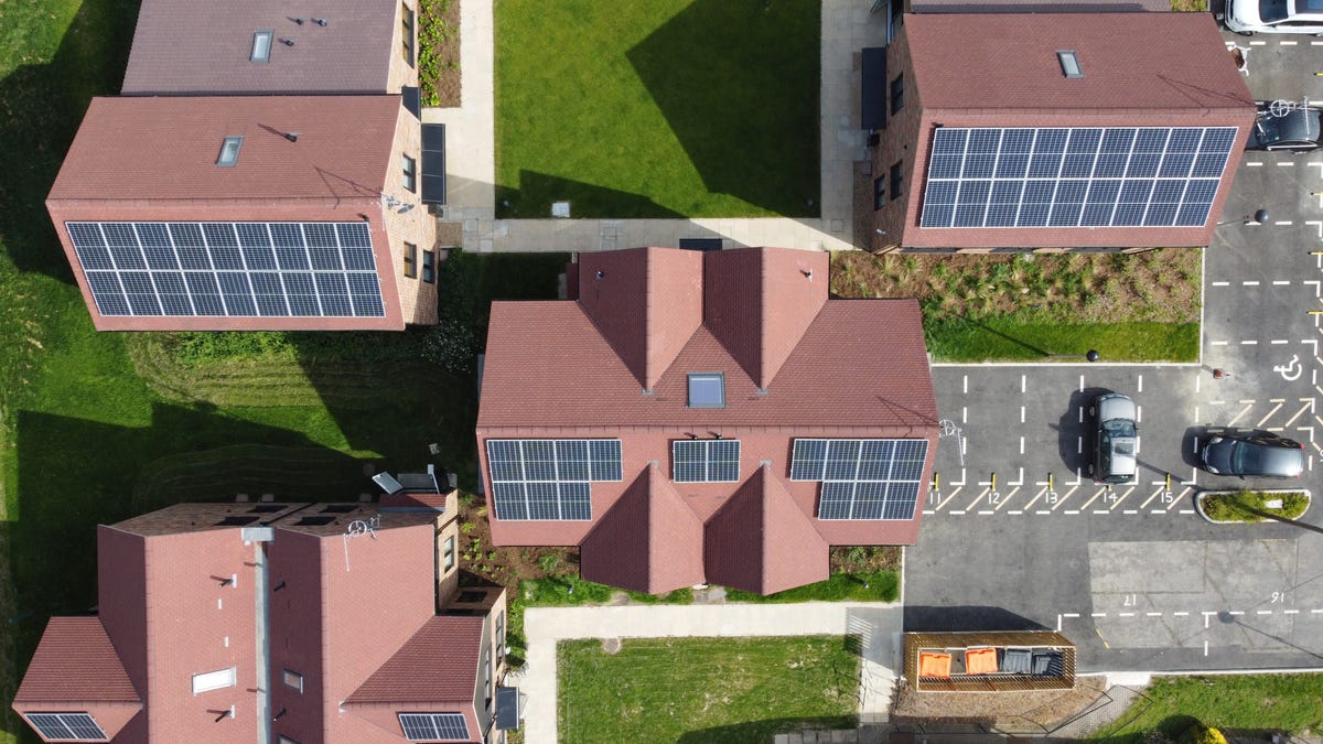 Aerial view of solar panels on homes with red roofs.