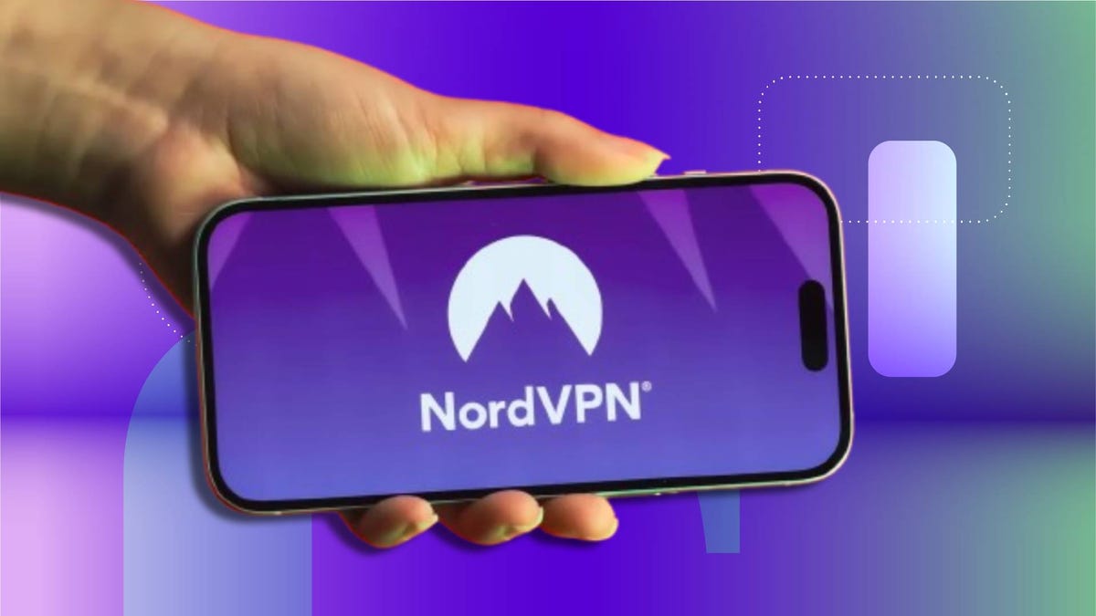 Hand holding a smartphone displaying the NordVPN logo on screen against CNET background