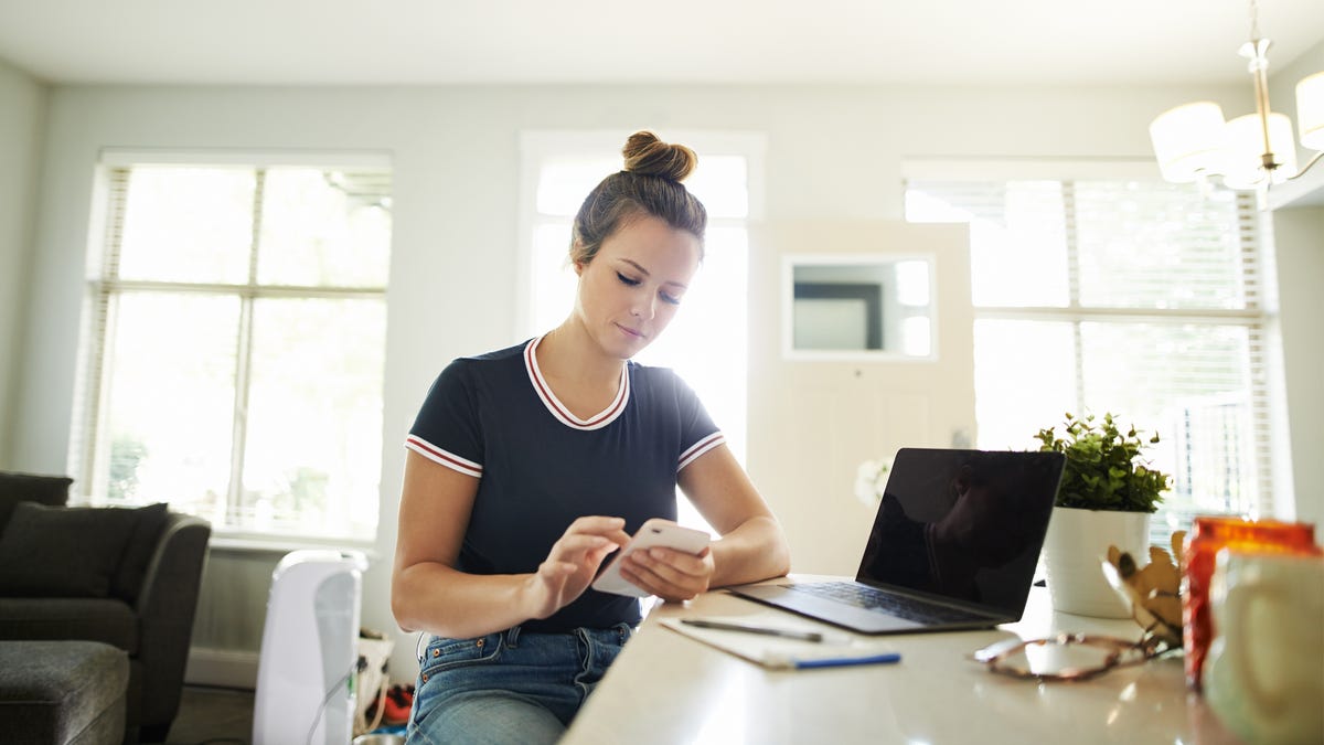 Woman sitting at table looking at her phone