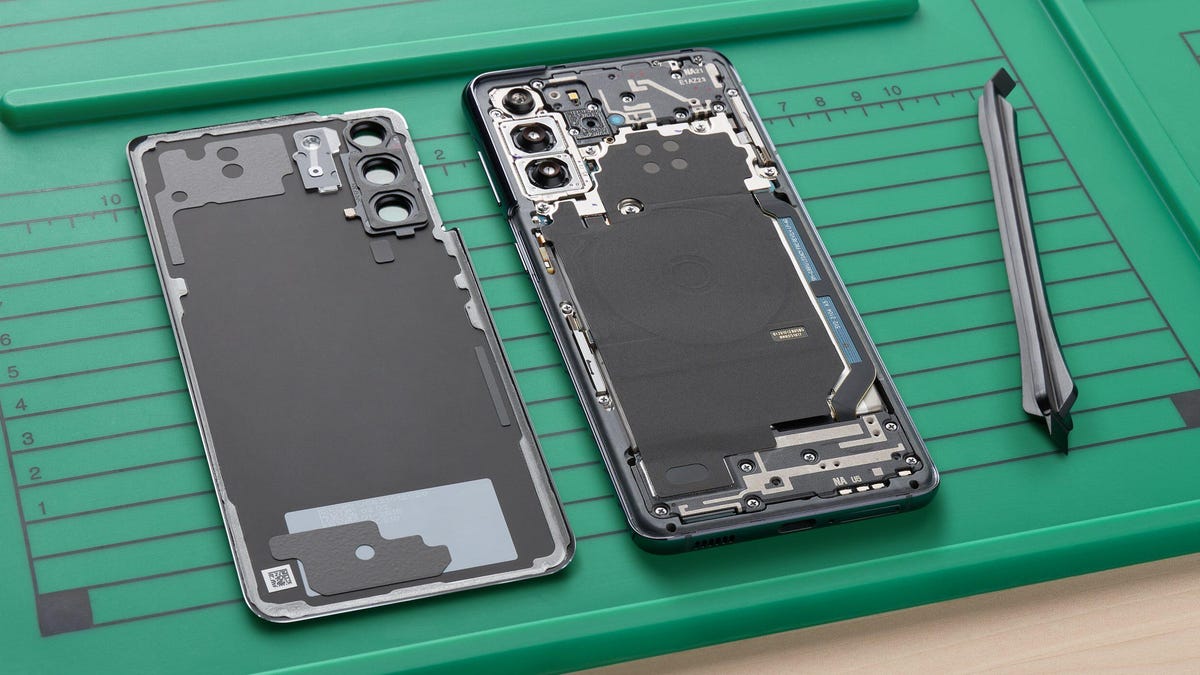 Open cellphone on green background, with inner workings exposed