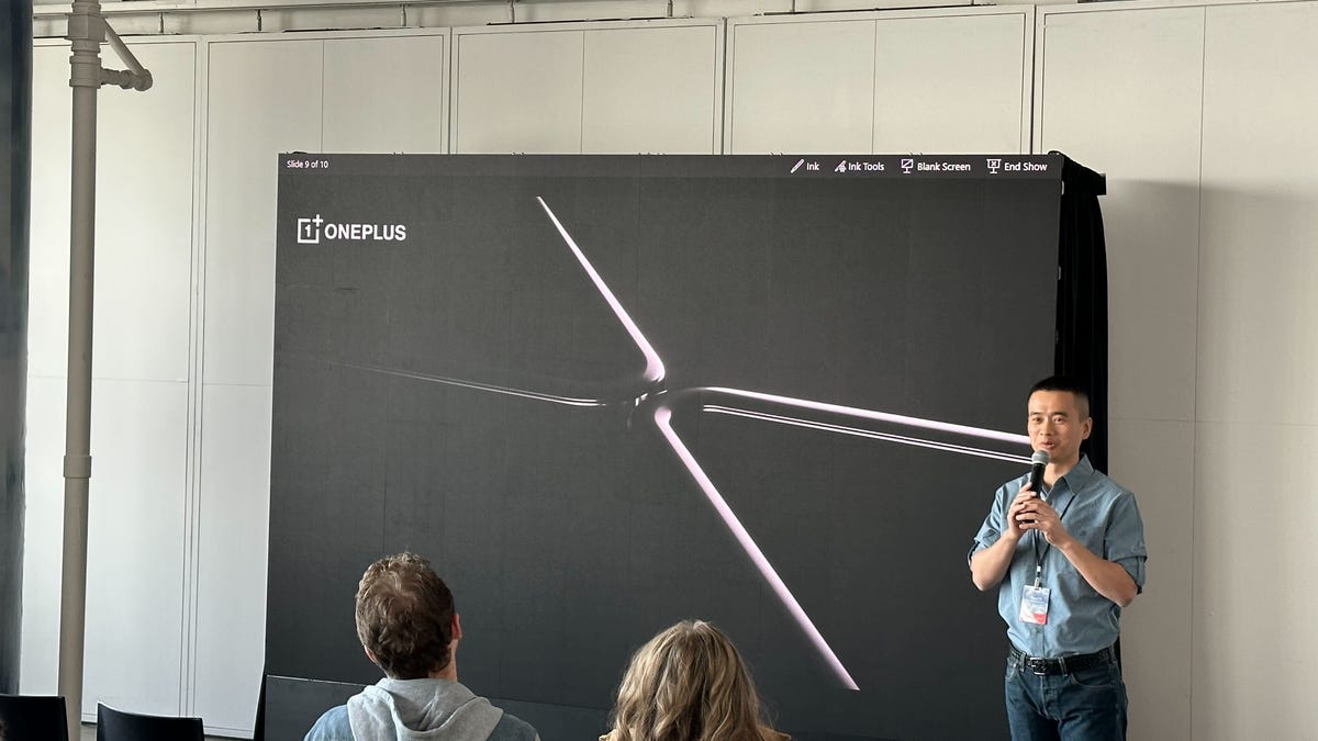 A man standing in front of a photo of a foldable phone
