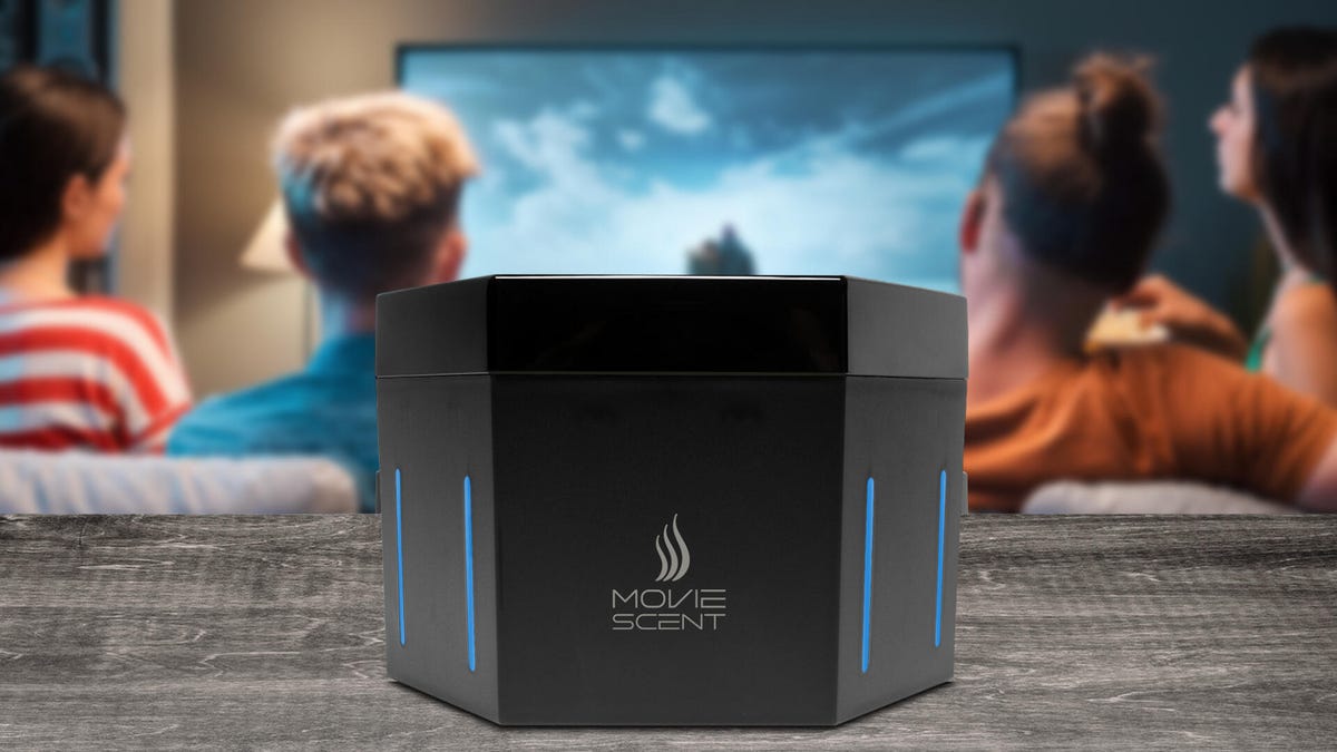 MovieScent device in the foreground as people watch TV in the background
