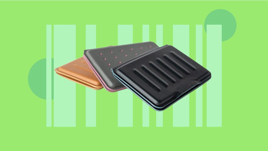 3 leather wallets on a green background