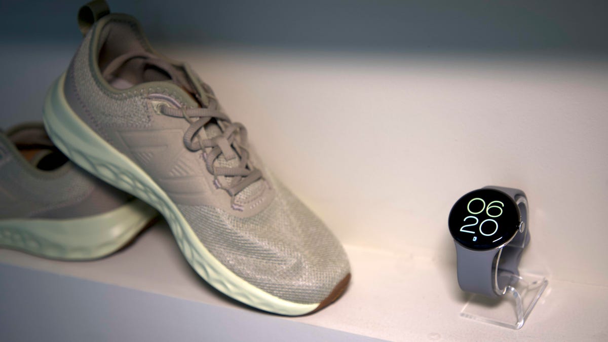 A pair of running shoes next to the Pixel Watch 3