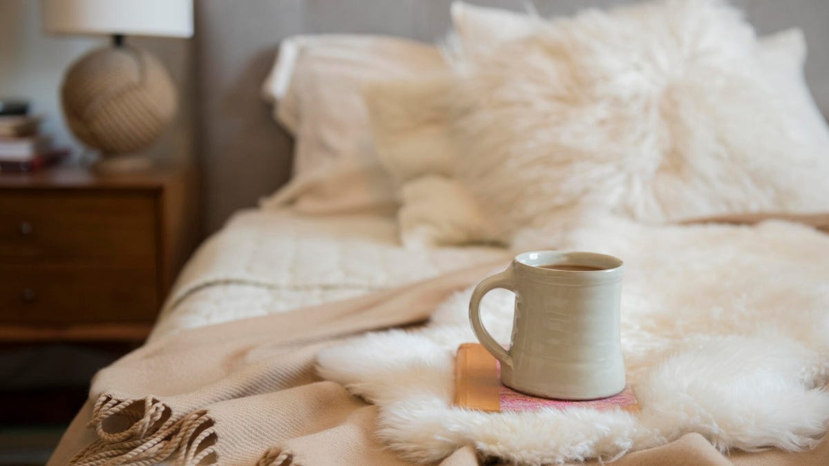 Cozy bedroom with a coffee cup on a bed