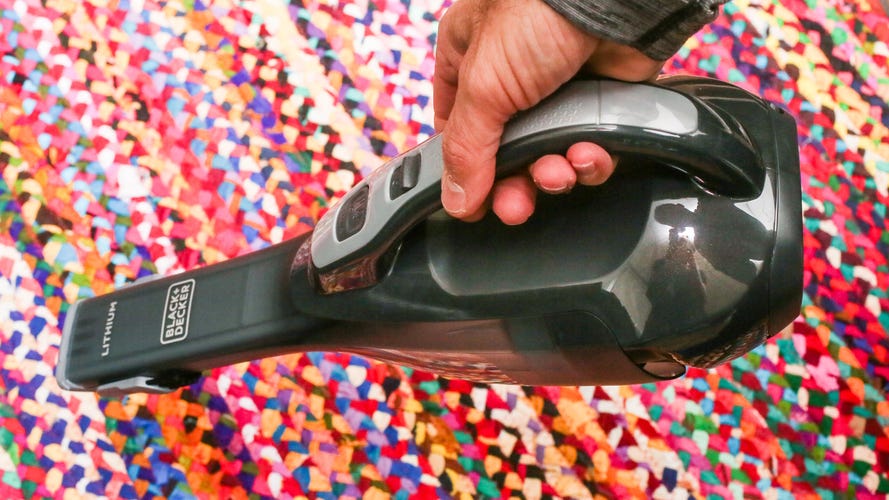 Black+Decker Dustbuster Advanced Clean being held near a colorful rug