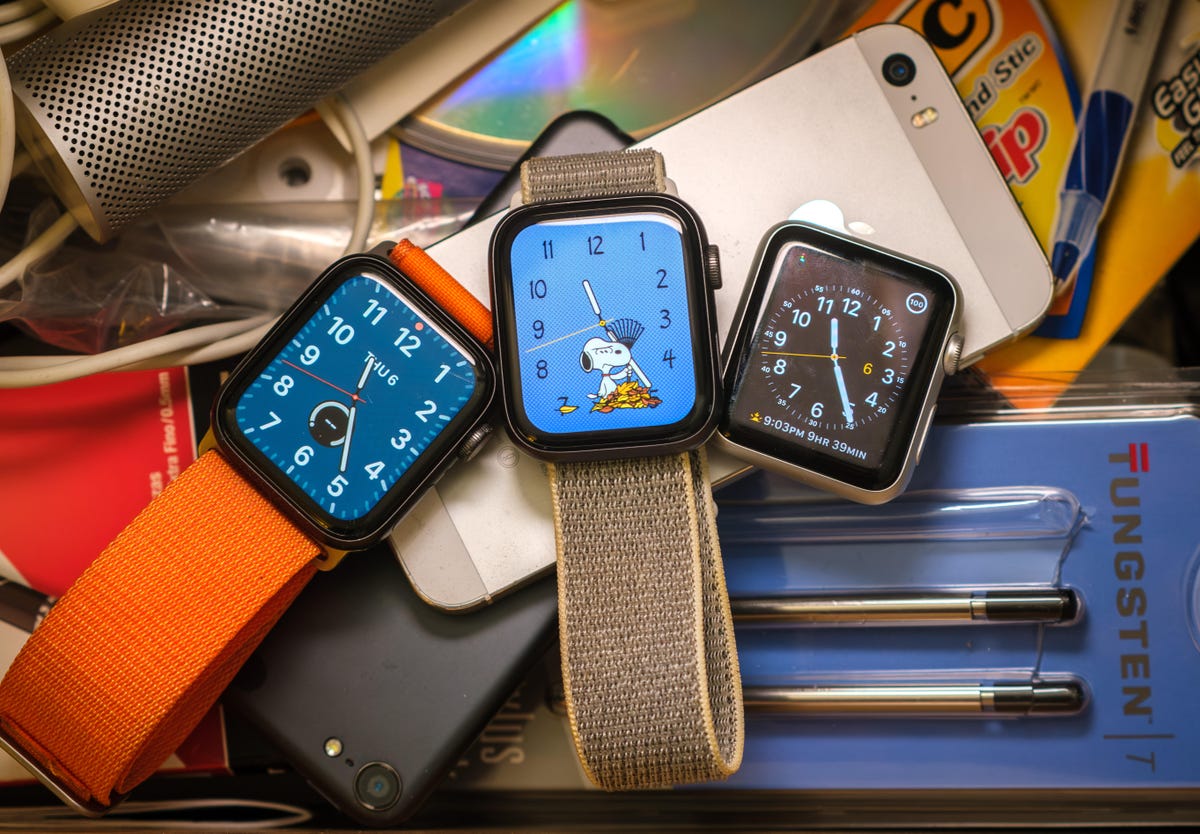 Three old Apple Watches in a drawer filled with other old tech including an iPhone, Apple iSight camera, and Palm Tungsten replacement styluses.