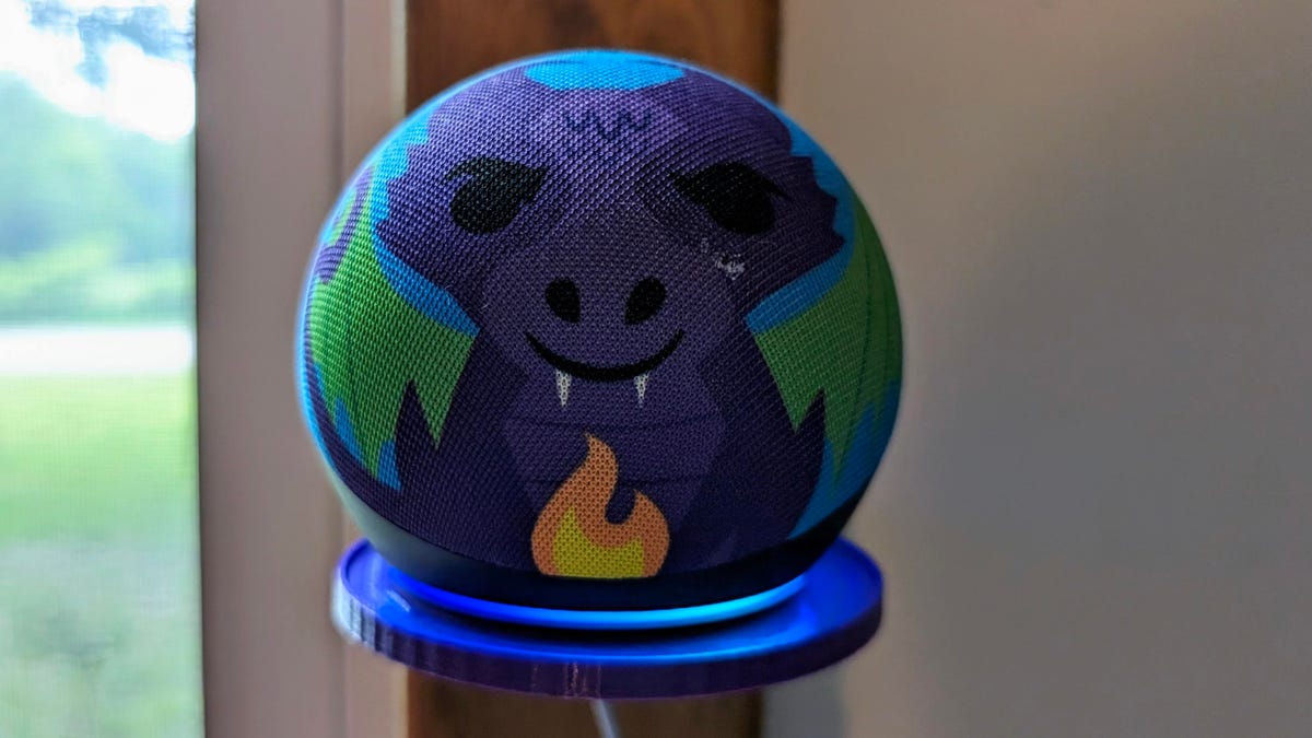 Amazon Echo Dot Kids dragon-themed smart speaker with the blue LED ring illuminated on the bottom.