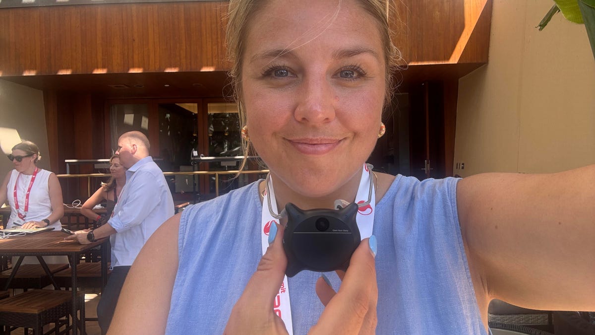 A woman holding a cat head-shaped wearable