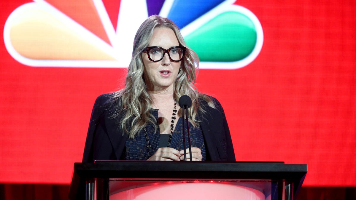 Jennifer Salke stands at a podium in front of the NBC 'peacock" logo