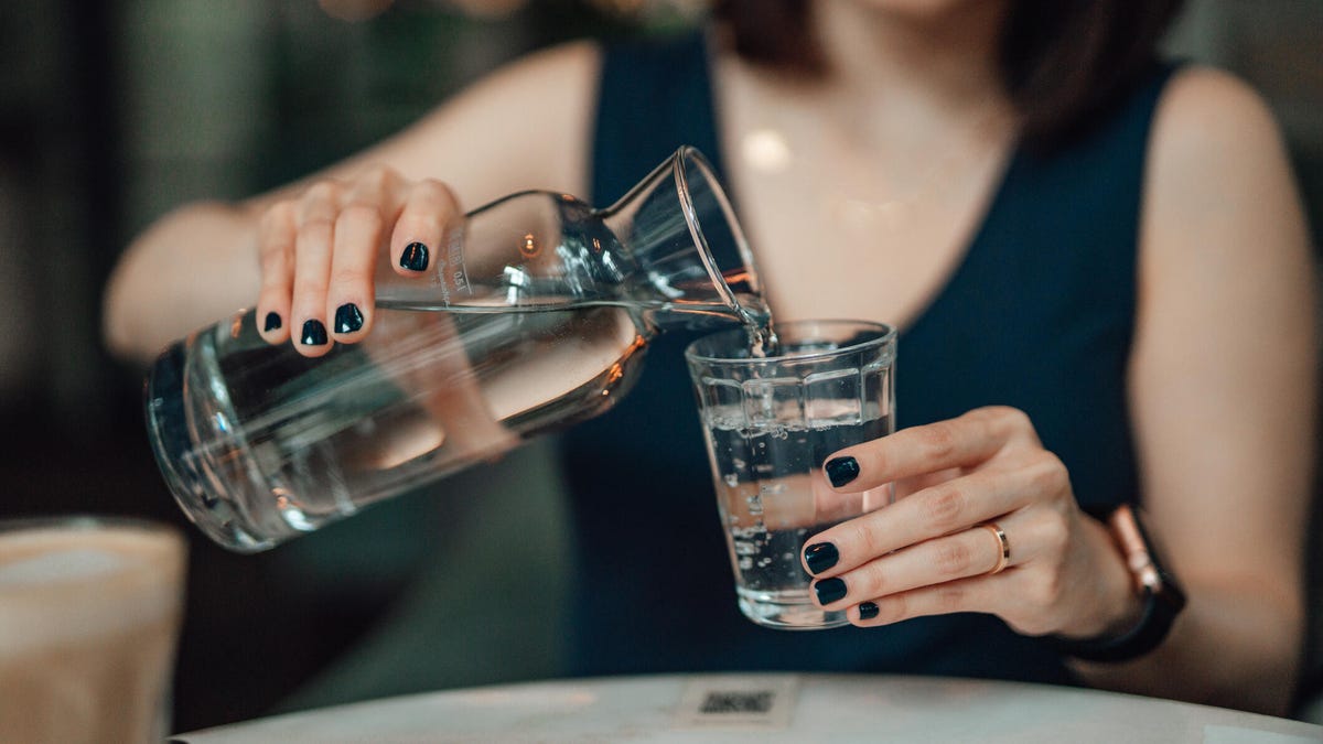 Person pours water glass