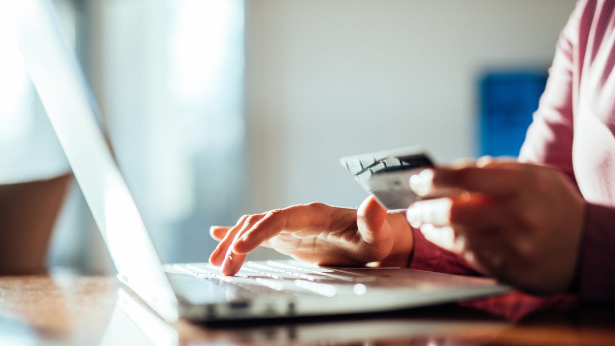 Person putting in credit card information at a computer.
