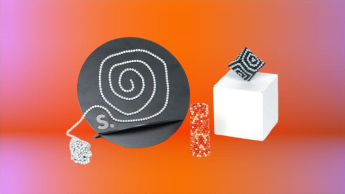 Speks office toys including magnetic putty and black and orange magnetic fidget balls displayed together against a gradient orange and pink background