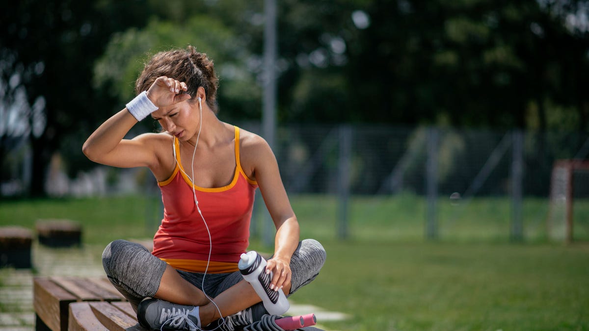 woman sitting on bench outside on hot day