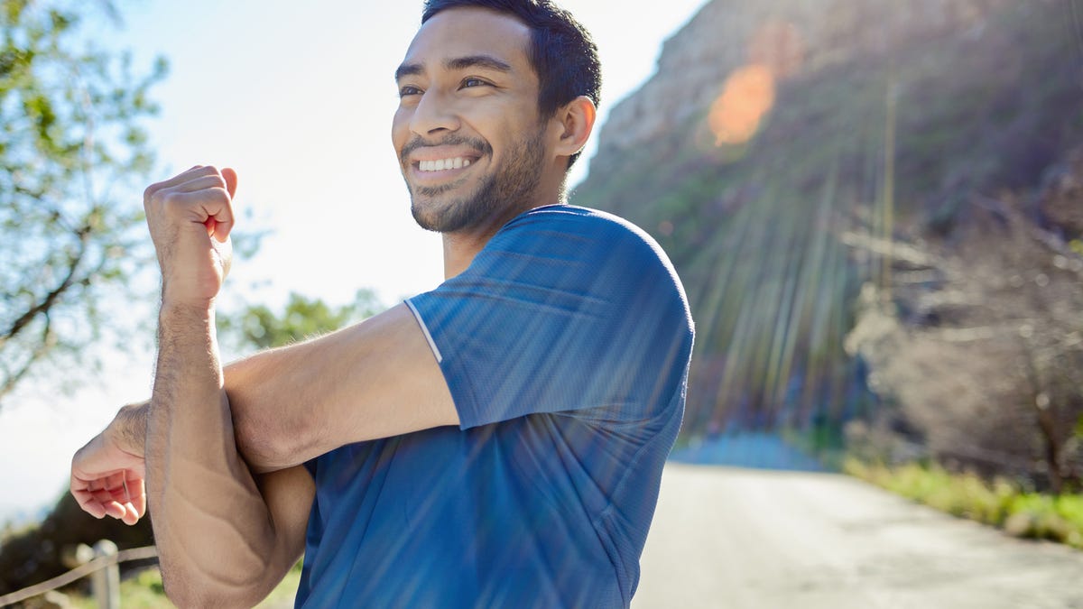 Portrait of a man happy while stretching outdoors.