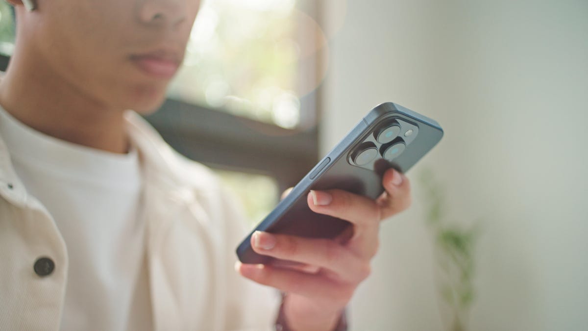 A young person holds a smartphone.