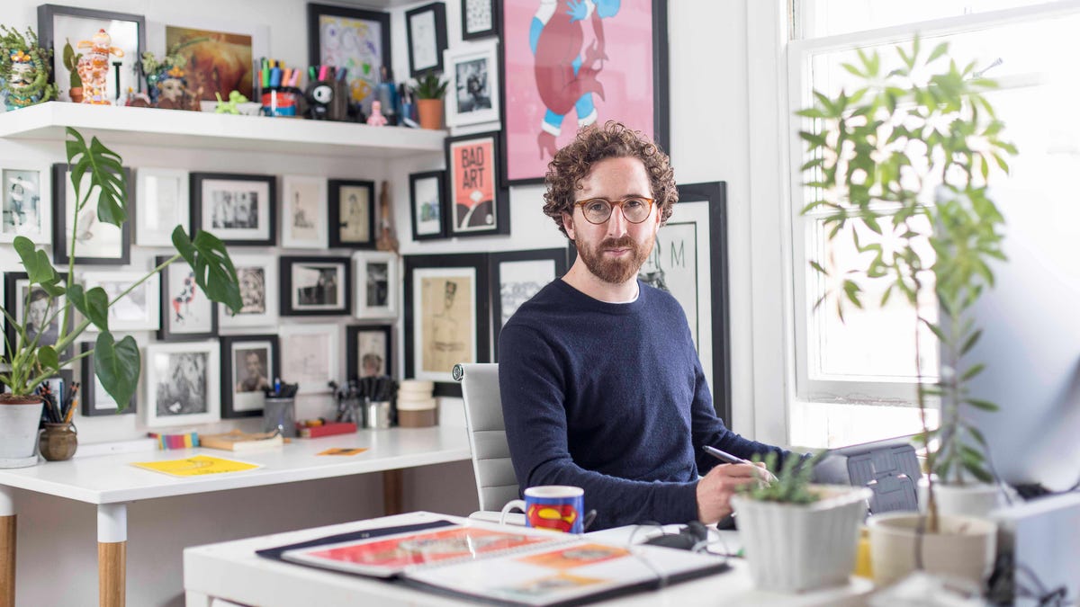 Tom Hovey sits at his desk near a window.
