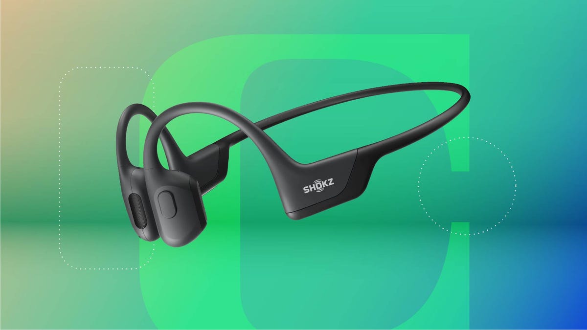 A pair of black open headphones against a green gradient CNET background.