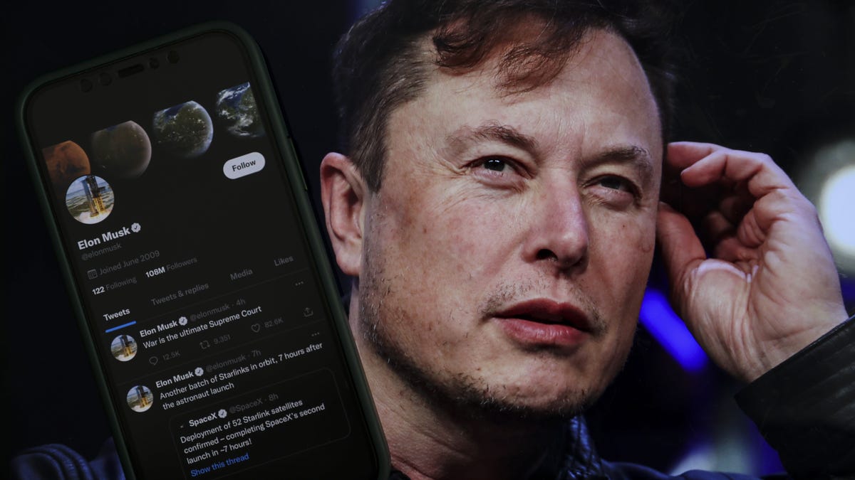 Elon Musk's Twitter profile on a mobile phone, in front of a photo of Musk on a computer screen