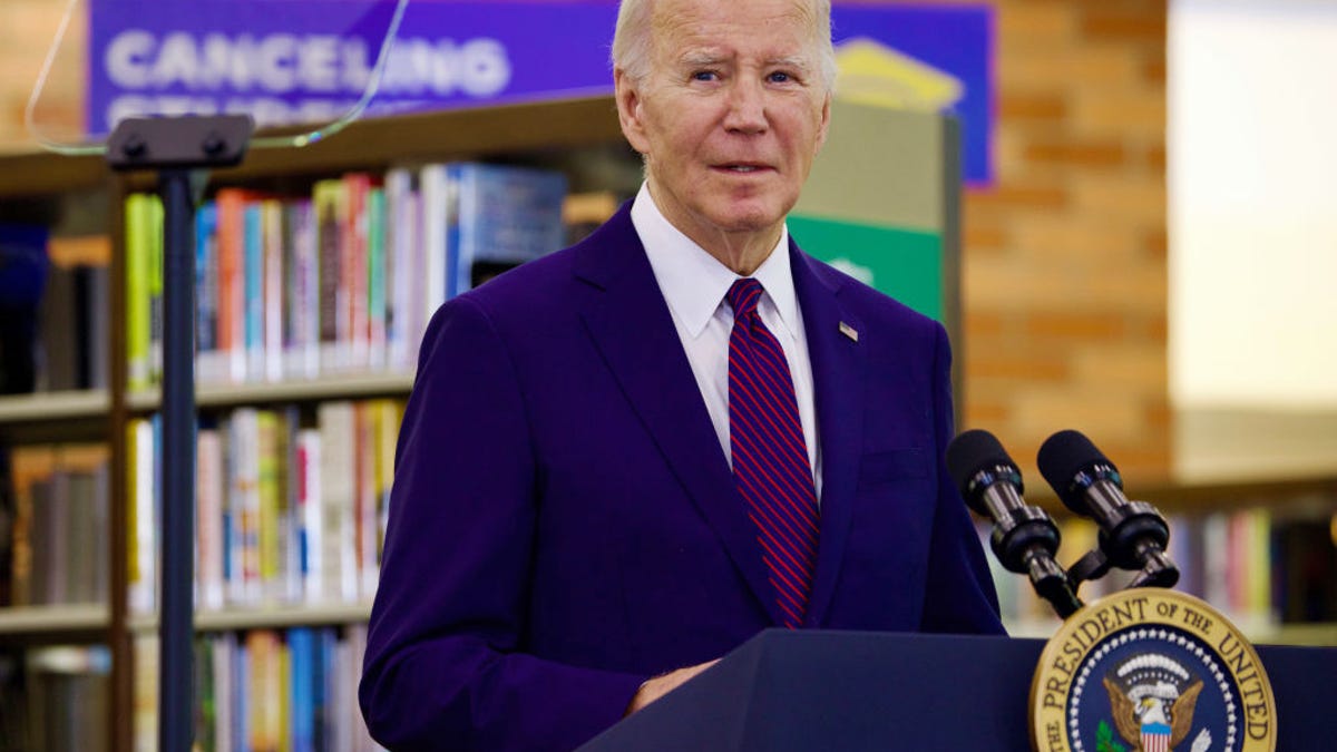 President Joe Biden gives a speech in front of a "Canceling Student Debt" banner