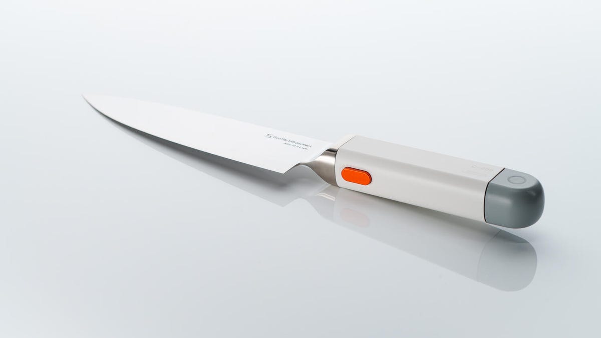The c-200 lying on a surface at an angle with an orange button exposed on the handle