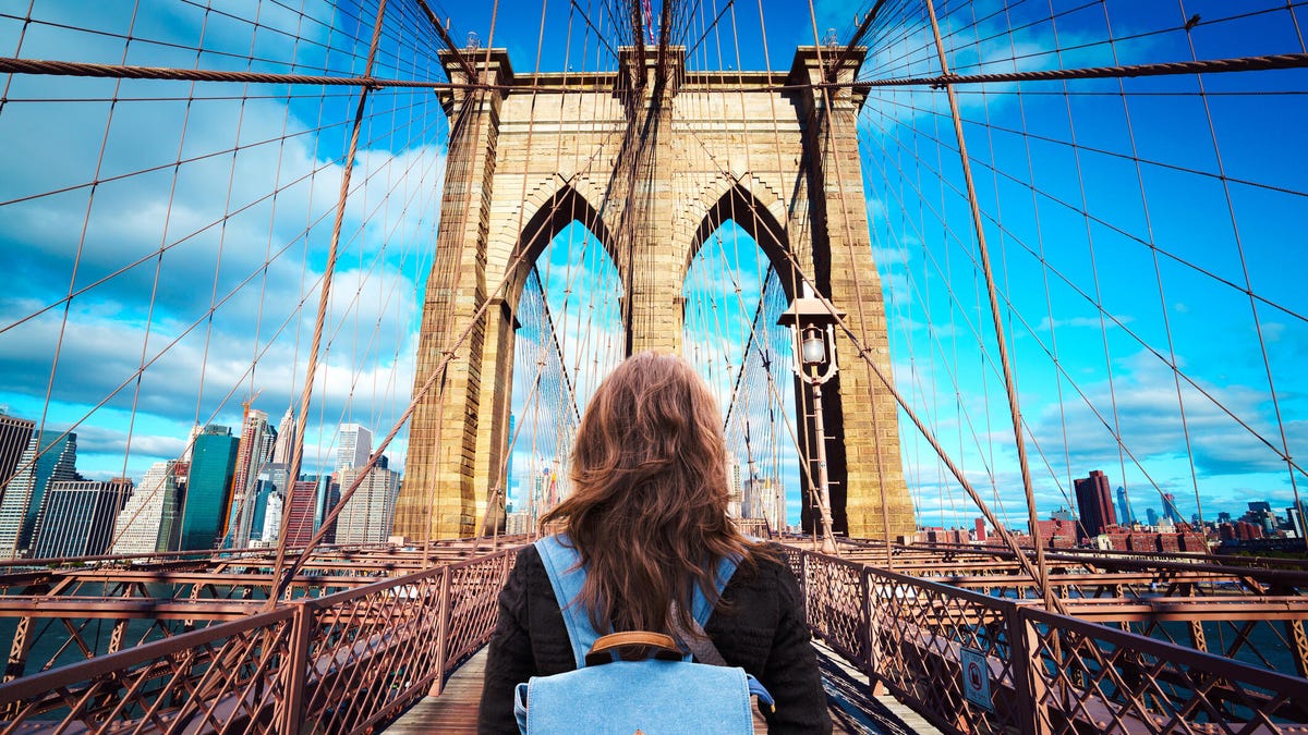 A woman standing in front of the Brooklyn Bridge