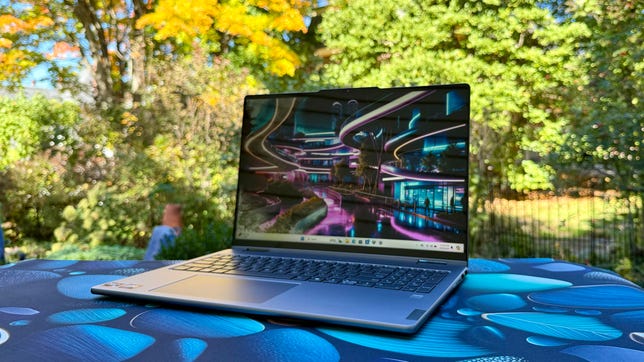 Lenovo Yoga 7 16 Gen 9 2-in-1 laptop in front of fall trees