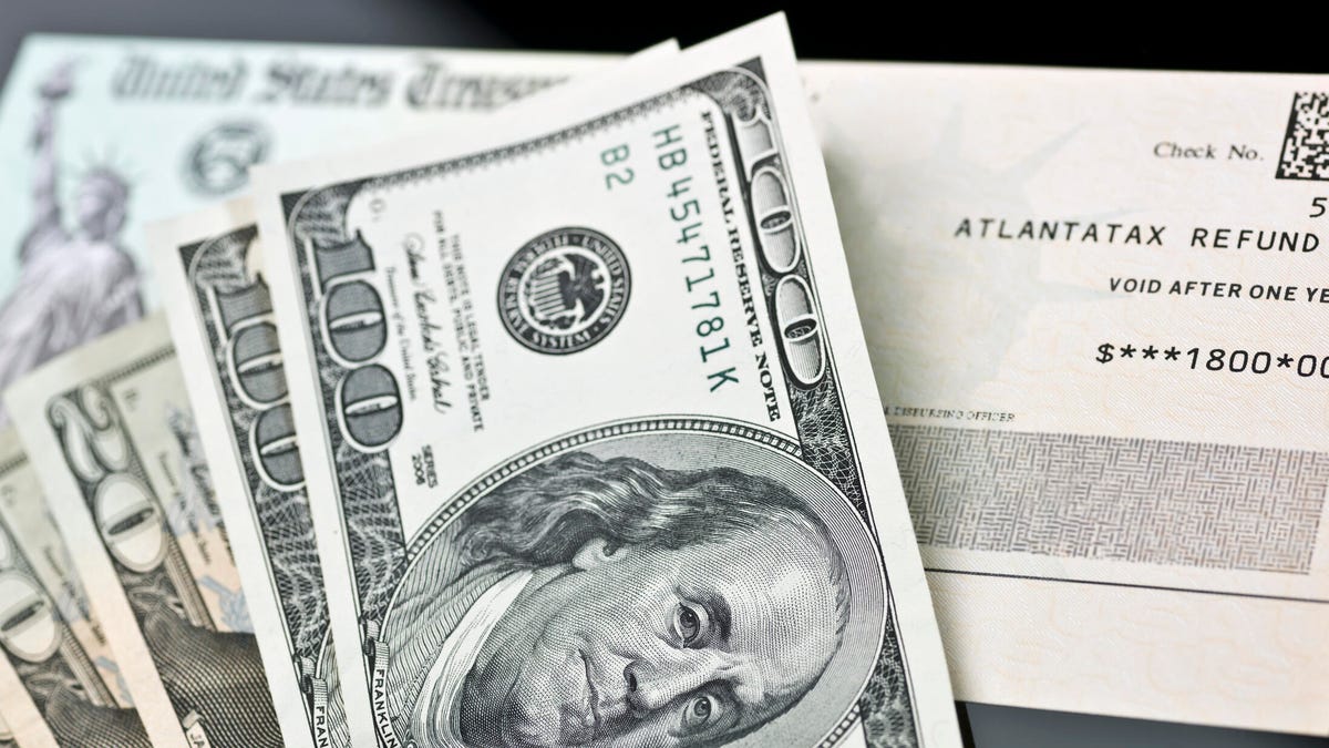 Cash bills laying on top of paper tax refund envelope