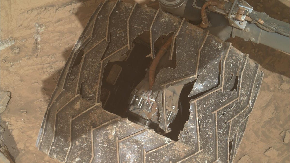 Curiosity rover wheel shows broken grousers and a big hole in the middle.