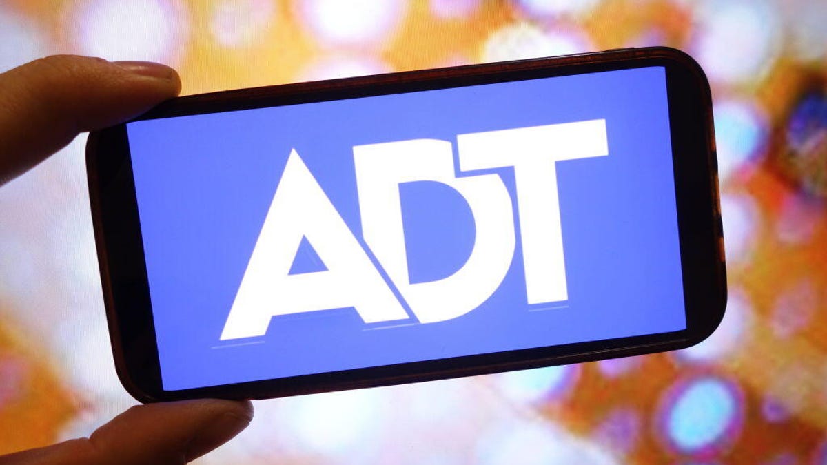 A phone with an ADT logo and blue background.