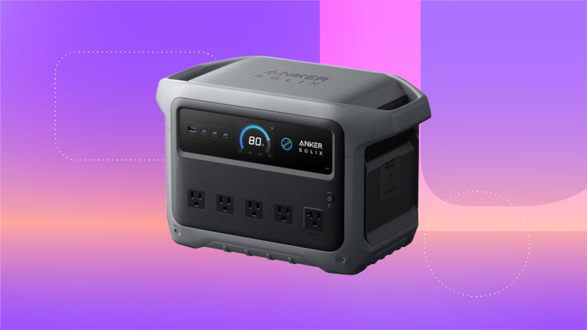 Anker Solix portable power station with rugged design, digital display showing 80% charge, four AC outlets and multiple USB ports. Set against a red, orange and yellow gradient background with abstract shapes.