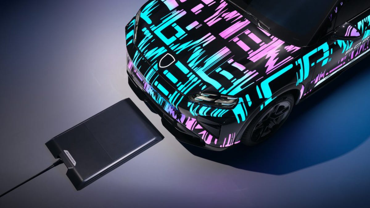 A disguised Porsche Cayenne lining up to the wireless charging pad