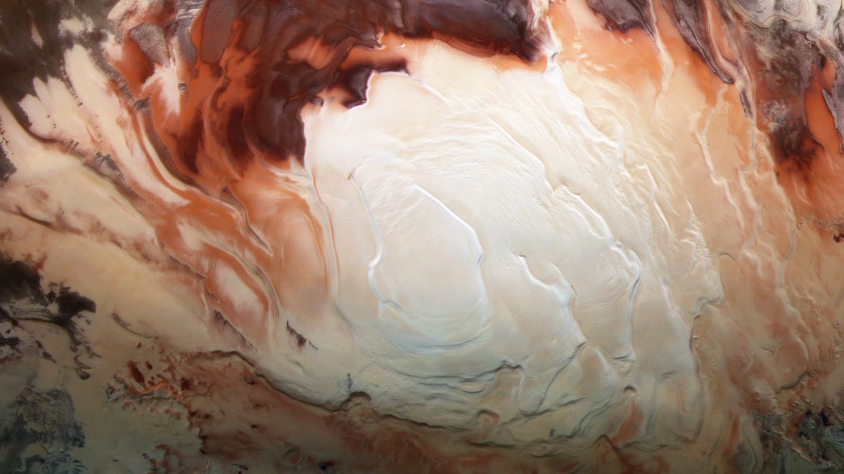 White swirls of ice look like cappuccino foam with dark red and brown surroundings on the Mars south pole.