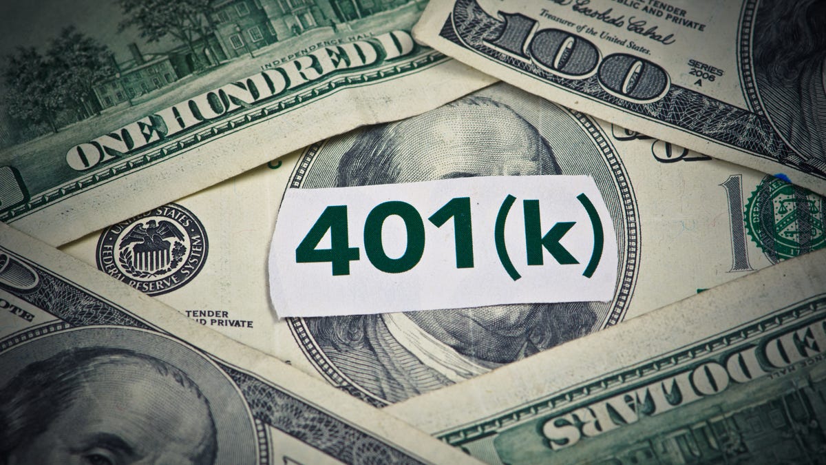 401(k) written on a piece of paper on top of scattered $100 bills