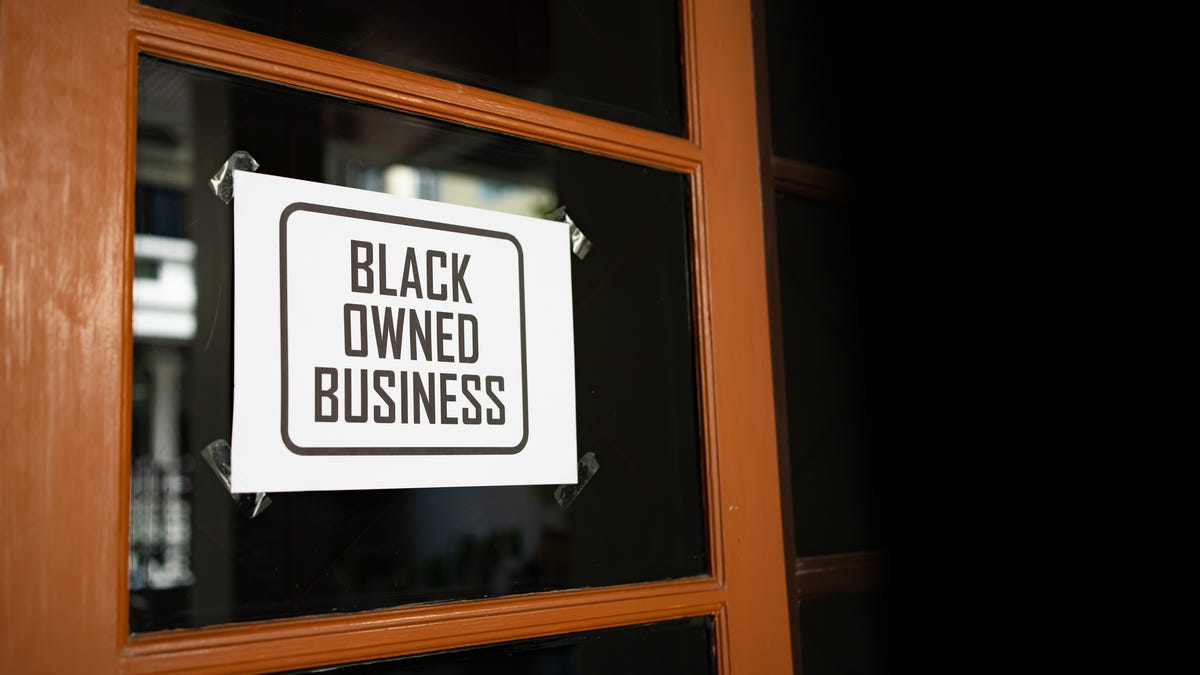 Black-owned business sign on a window.