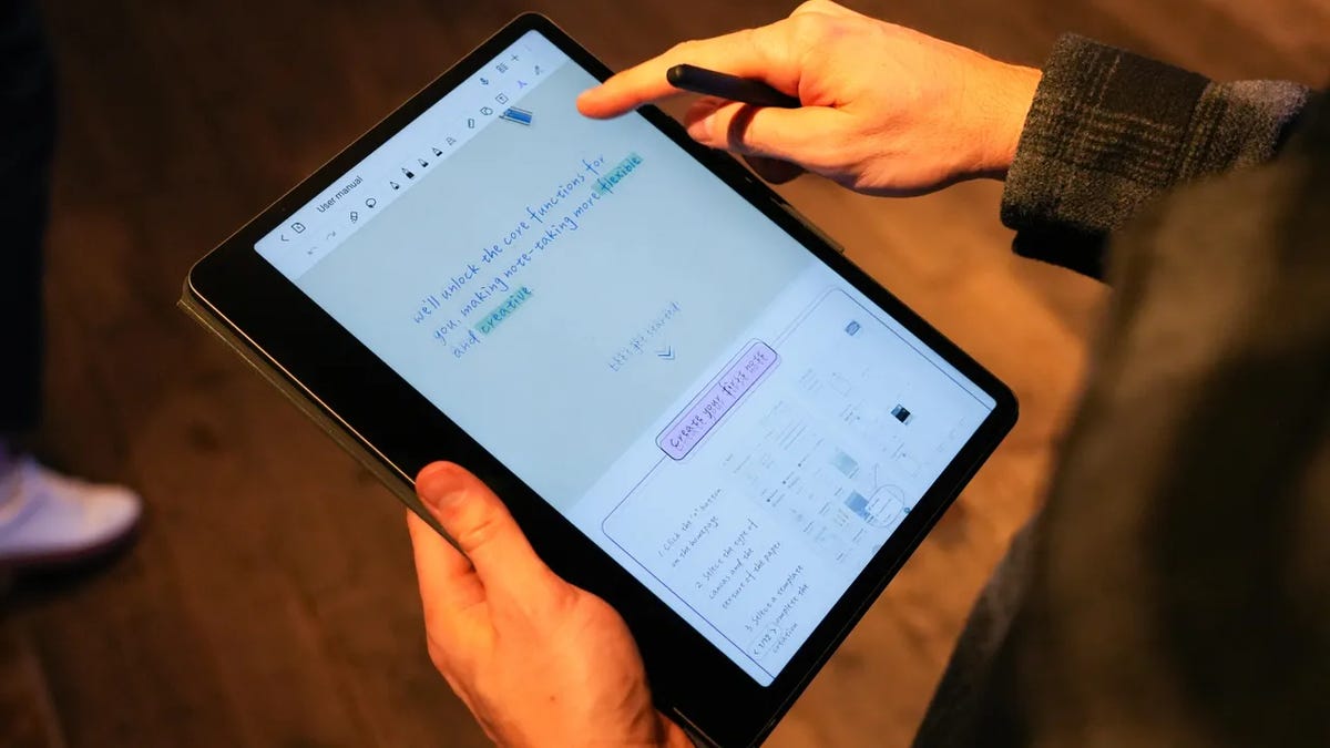 hands holding the TCL Note A1 tablet and pointing to notes on the screen