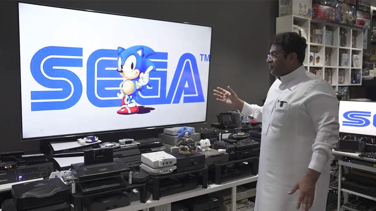 Ibrahim Al-Nasser stands in front of some of his gaming consoles