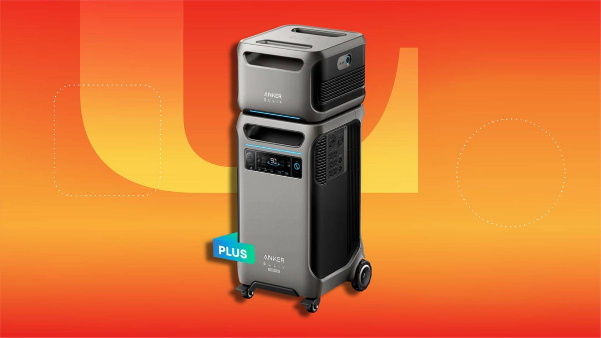 A large, wheeled portable power station with a stacked modular battery design, front display screen, multiple outlet ports on the side, and a sleek gray finish set against CNET background