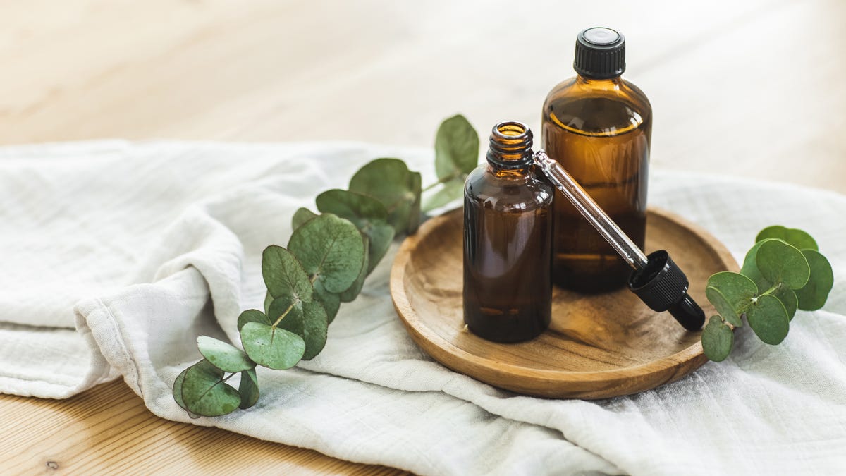 Essential oil dropper and bottles with eucalyptus leaves.