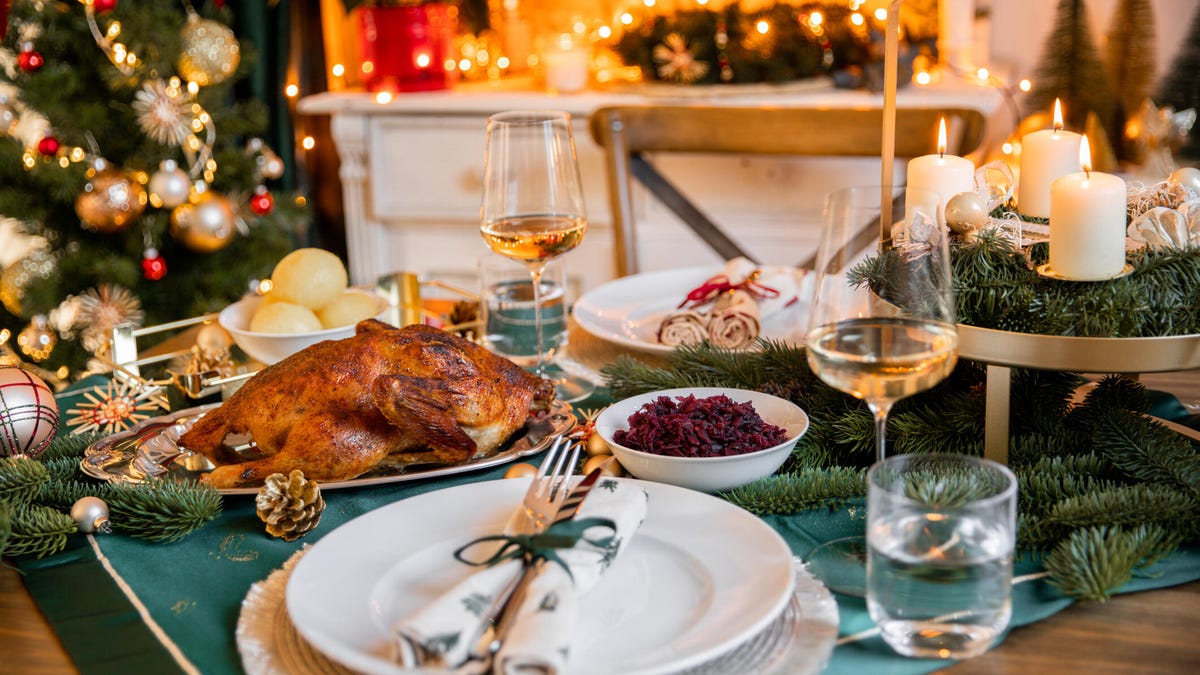 A photo of a holiday meal on a dining table in front of Christmas decorations