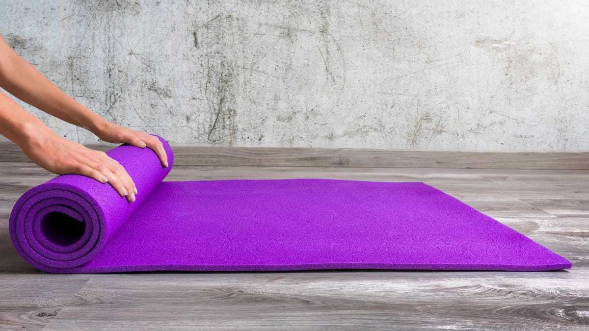 purple yoga mat being rolled up