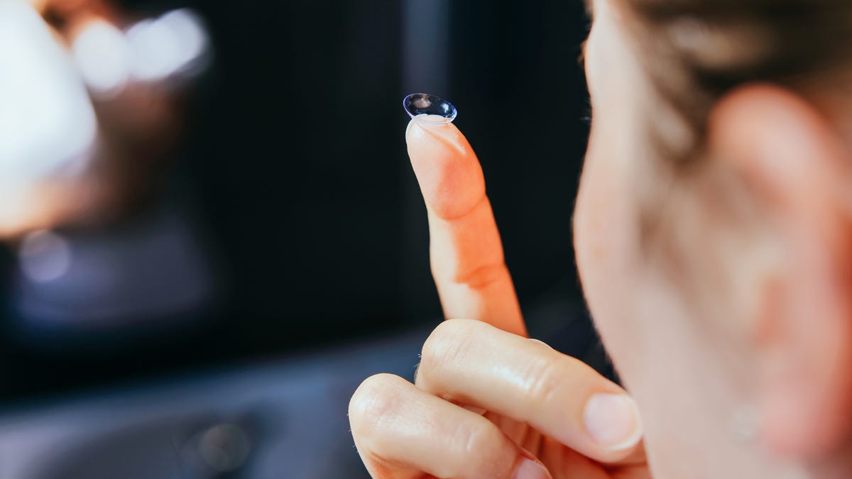 Woman holding contact lens