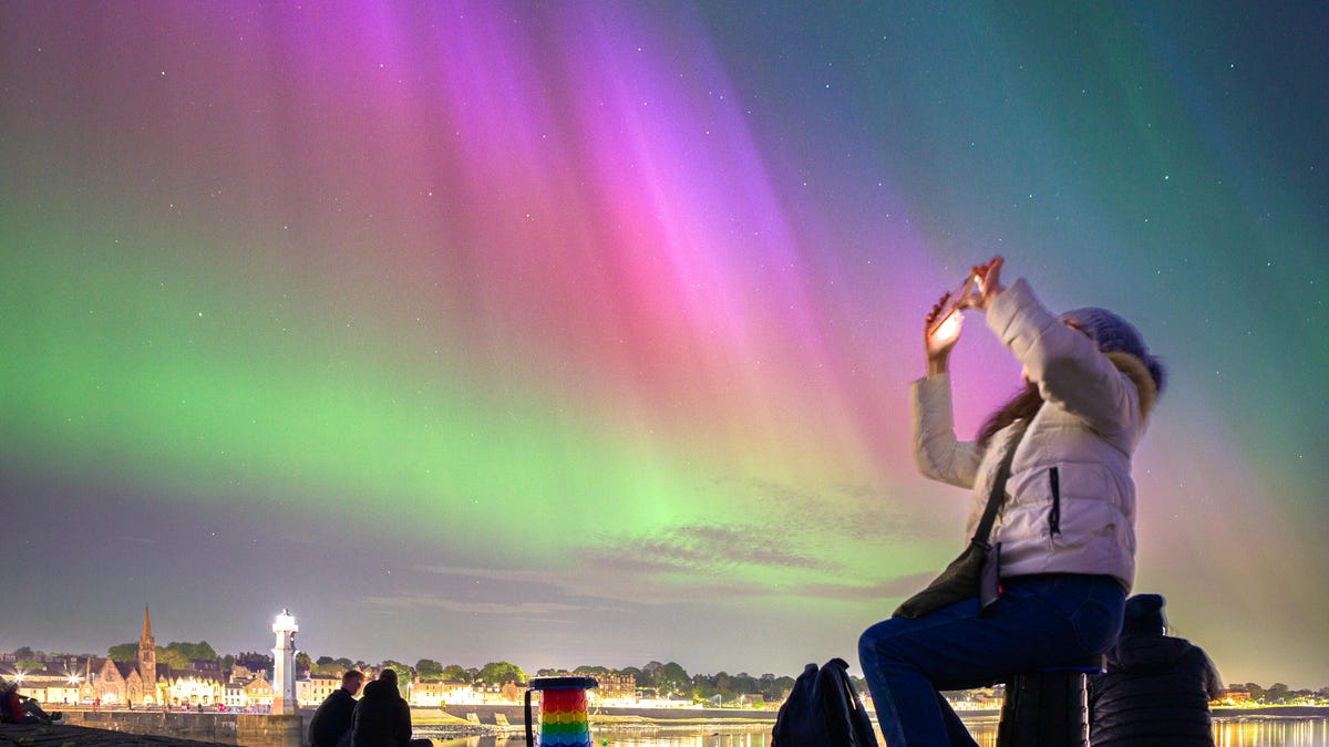 Image of a person photographing the aurora on a phone