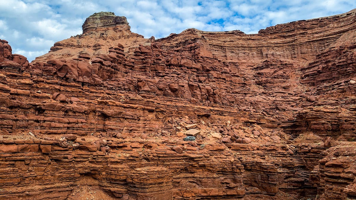 Far-away image of a 2023 Honda Pilot TrailSport prototype in front of a desert mountain landscape