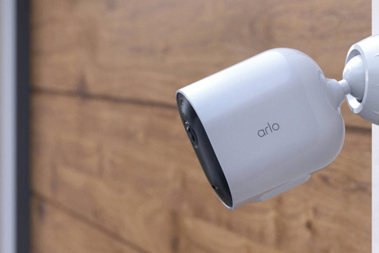 An Arlo Pro cam mounted to a wooden wall.