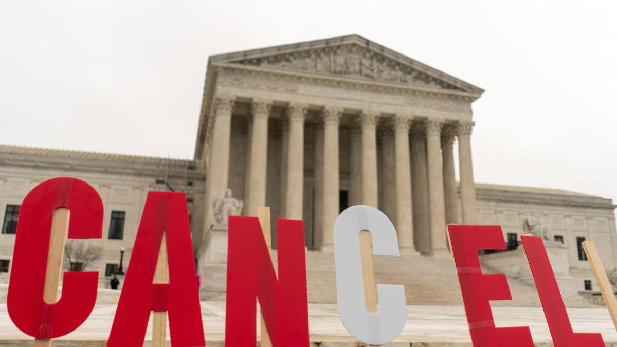 Supreme Court building with sign reading "Cancel" in front of it.