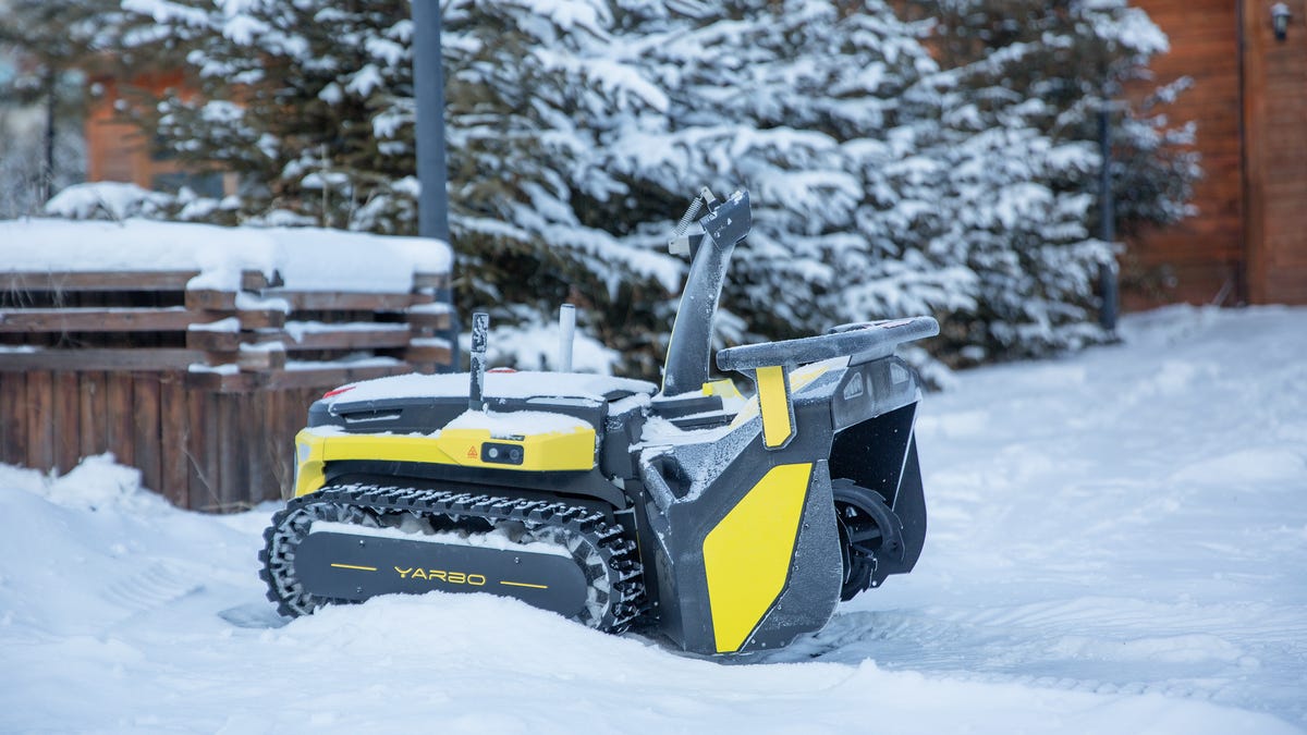snow plow robot blowing snow in a yard