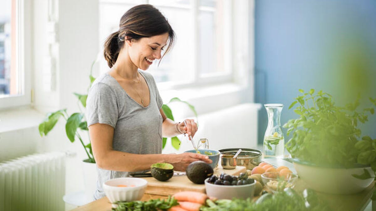 woman smiling surrounded by fresh produce